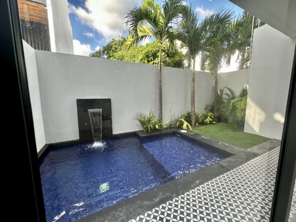 Casa en venta av huayacan - Alberca con cascada integrada en patio exterior con diseño moderno