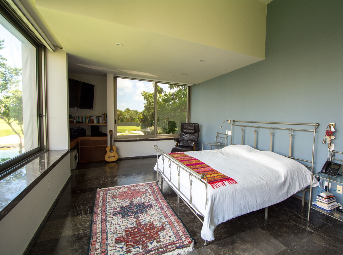 Casa en venta en cancún country club - recámara principal vista hacia la cama y ventana lateral