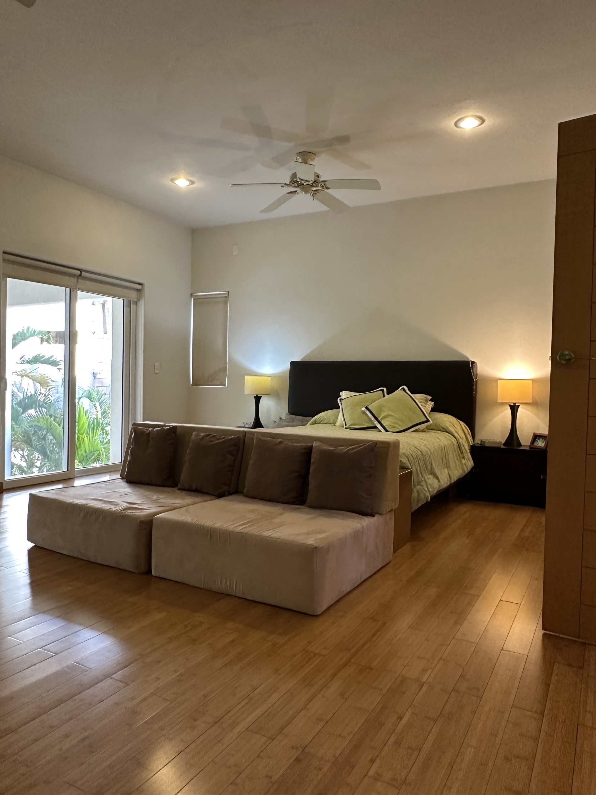 Casa en venta en lagos del sol cancun - Recámara luminosa con piso de madera y luces cálidas