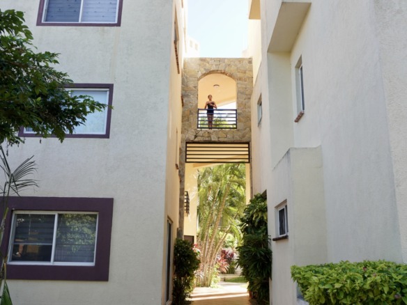 Departamento en venta en centro cancún - Vista exterior con edificios de tonos claros conectados por pasillos con barandales