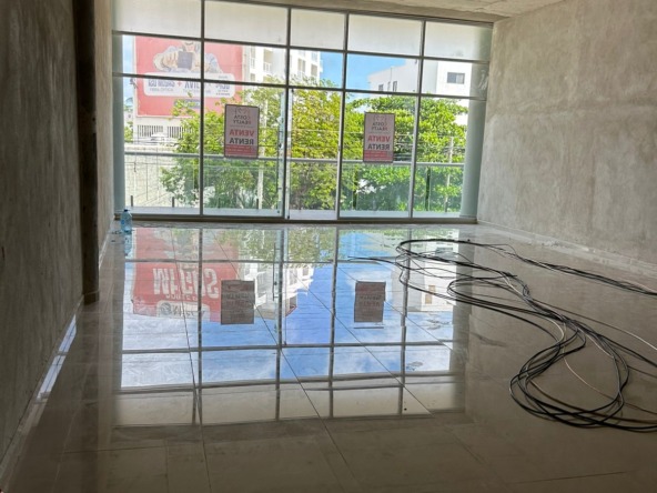 Local en venta o renta puerto cancún-Local con amplios ventanales de cristal, piso de loseta brillante y techo de concreto