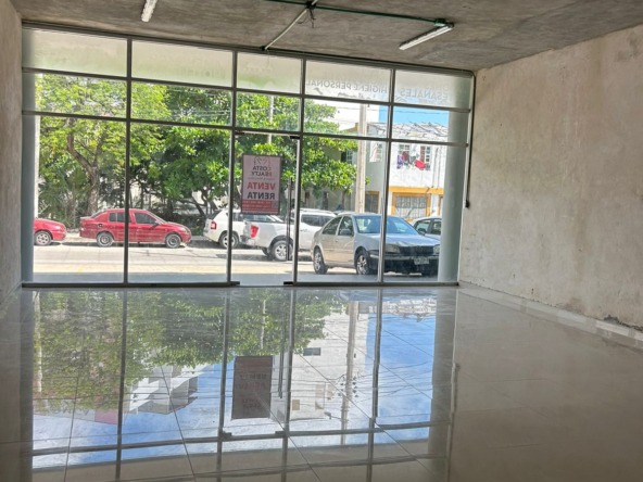 Local en venta o renta puerto cancún-Local con amplios ventanales de cristal, piso de loseta brillante y techo de concreto
