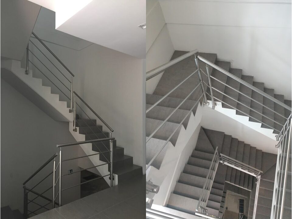 oficina en venta en cancún centro - Escaleras interiores de edificio con acabados modernos, escalones de concreto y barandales de acero inoxidable